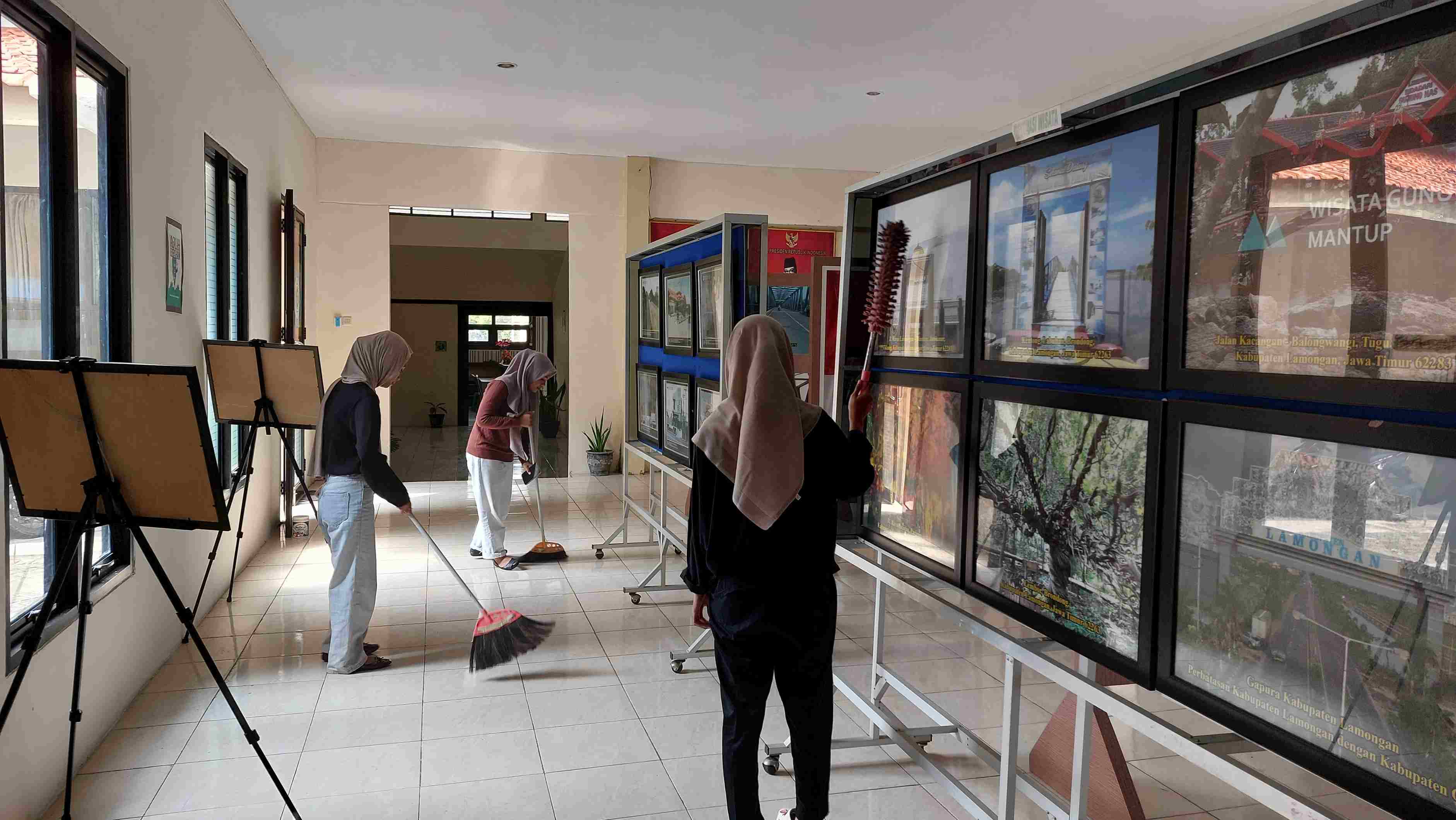 MENJAGA KEBERSIHAN RUANG PAMERAN FOTO ARSIP