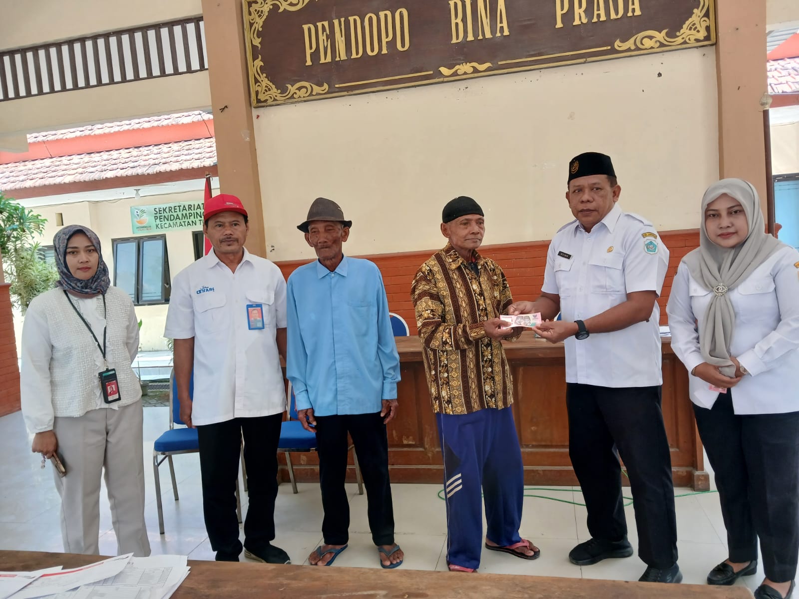 Foto: Plt. Camat Turi Serahkan Bantuan PKH Plus (Jaslut) Secara Simbolis di Pendopo Kecamatan Turi